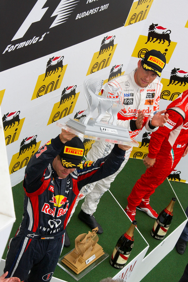 Second placed Sebastian Vettel lifts his trophy