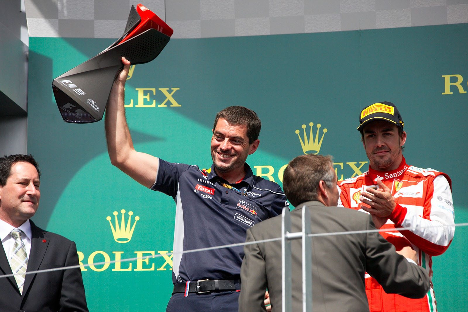 Vettel’s Red Bull Racing race engineer Guillaume Rocquelin raises his trophy for the winning constructor during the podium ceremony