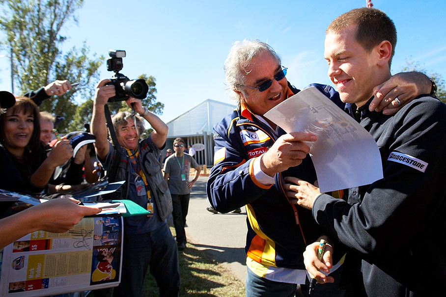 Renault F1 boss Flavio Briatore jokes around with Red Bull's Sebastian Vettel during an autograph session