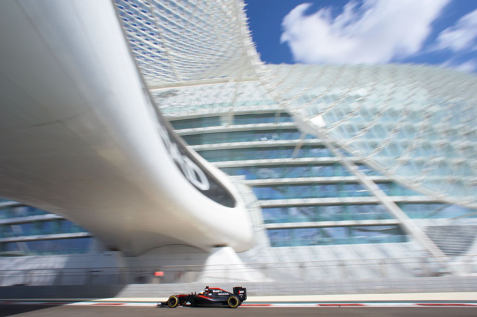 Fernando Alonso drives his McLaren-Honda below the Yas Viceroy Abu Dhabi Hotel, which is built across the F1 Circuit
