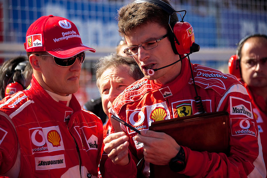 Michael Schumacher's race engineer Chris Dyer giving latest technical information under the eyes of Jean Todt and Luca Colajanni