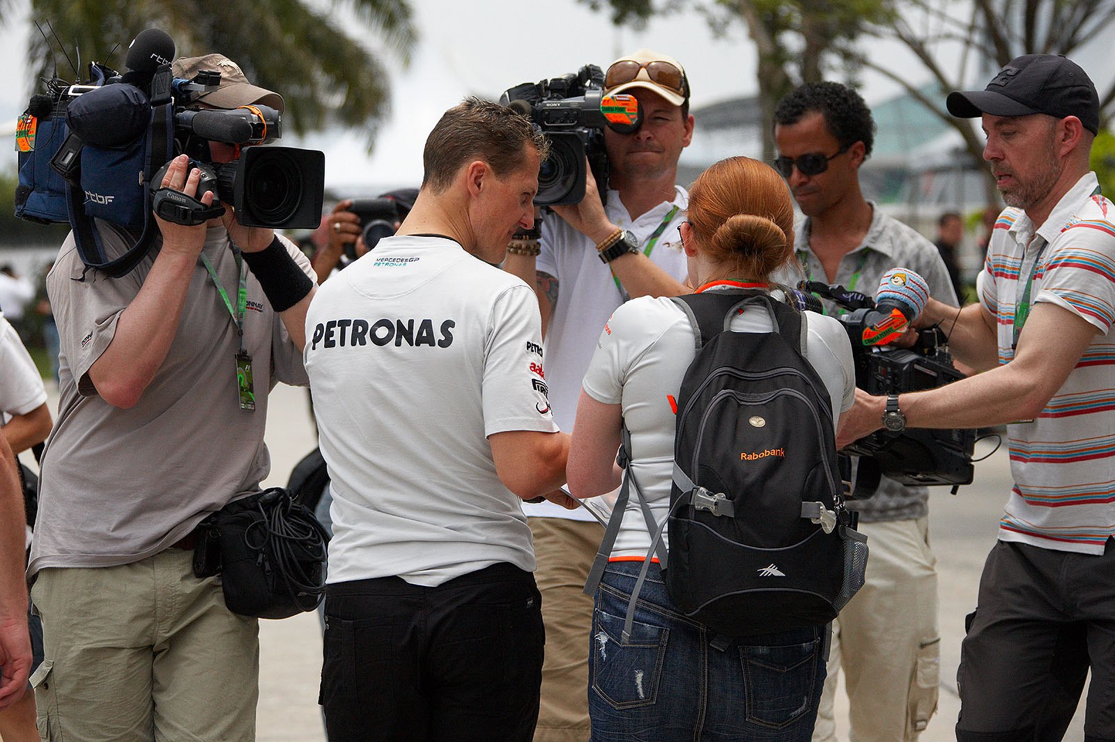 Michael Schumacher signs autographs under the lenses of eager TV cameras