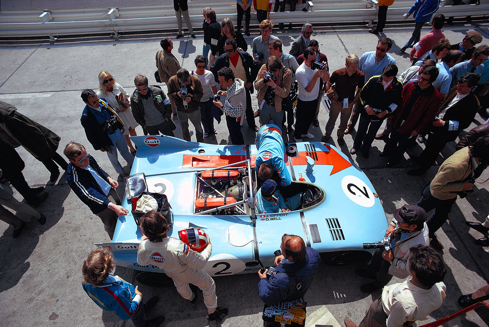Jo Siffert (CH) waits besides the Porsche 908/03 012 whilst mechanics try to fix chassis problems