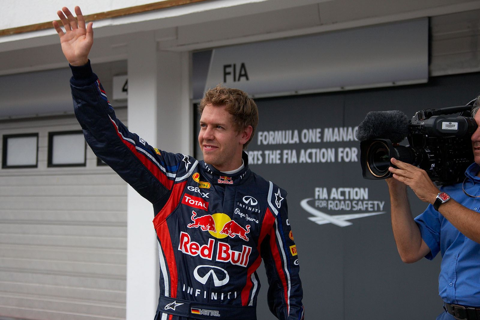 Polesitter Sebastian Vettel, Red Bull Racing, waves at the international media after qualifying