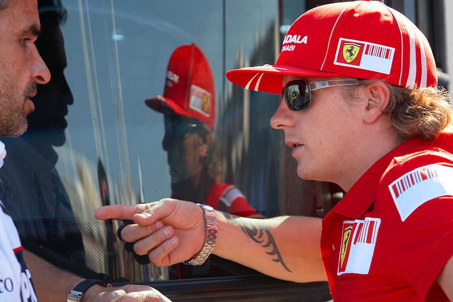 Ferrari driver Kimi Raikkonen discusses with his former team manager at Sauber Beat Zehnder