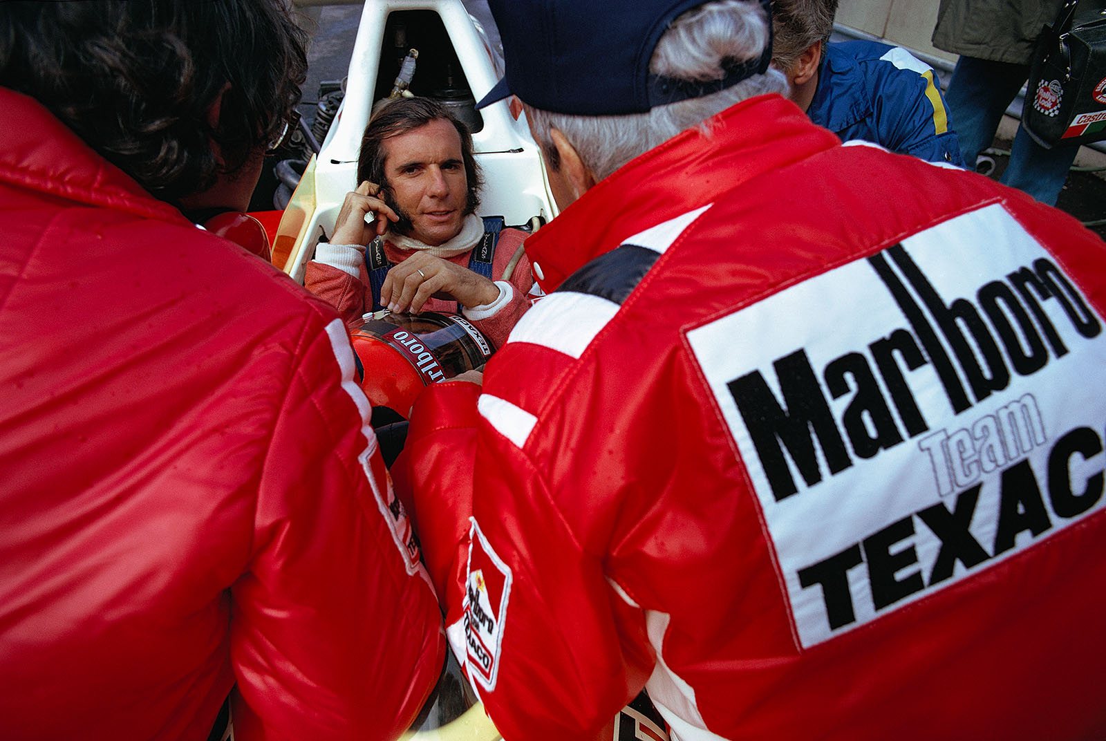 1972 World Champion Emerson Fittipaldi talks to McLaren team boss Teddy Mayer (right)