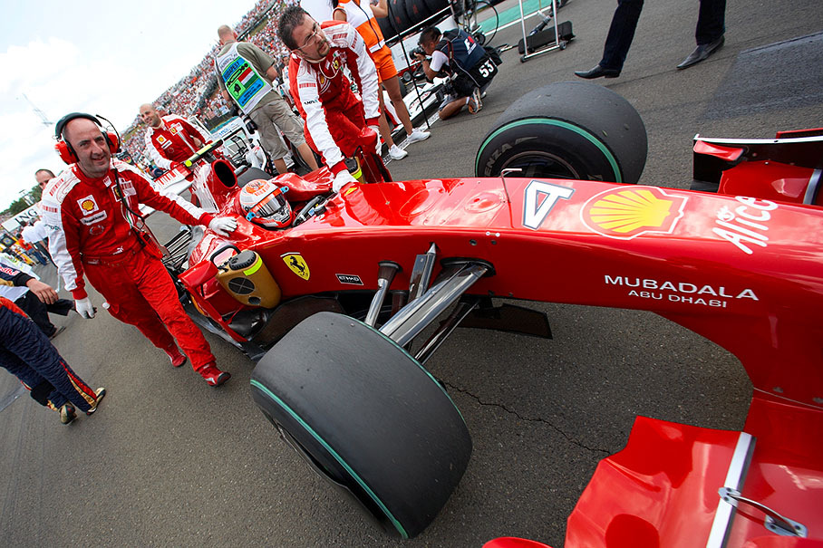 Kimi Raikkonen's Ferrari is being pushed to his position on the grid