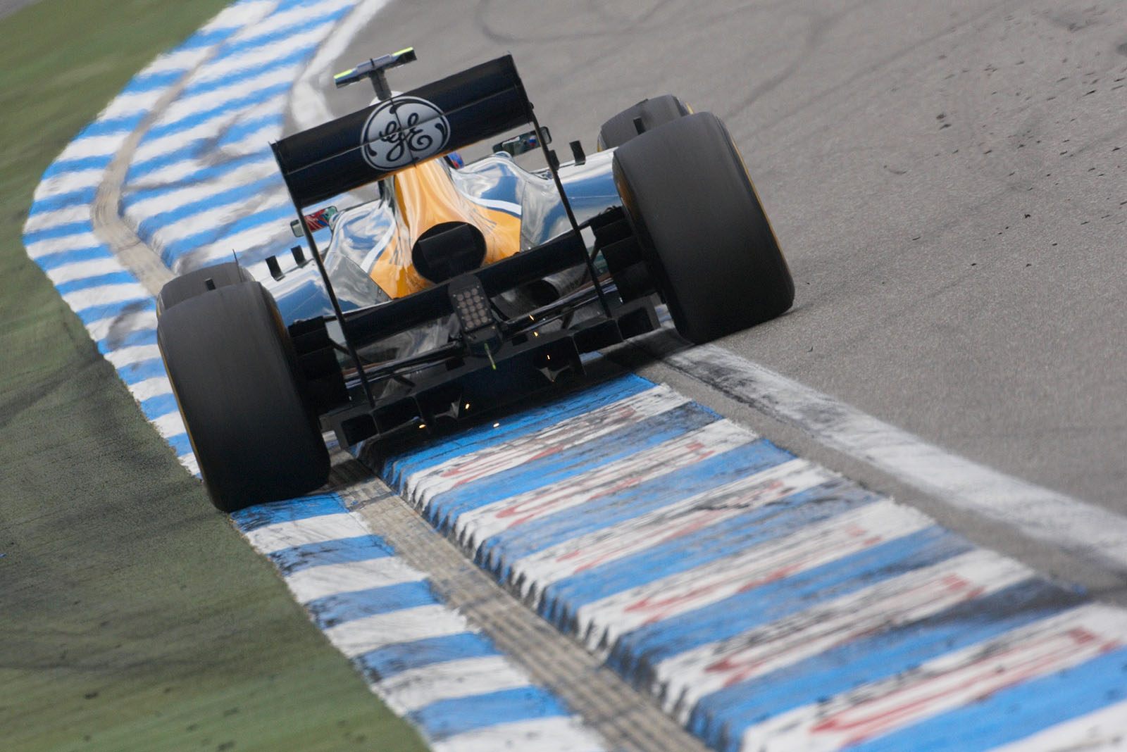 Vitaly Petrov, Caterham, emits sparks on the curb