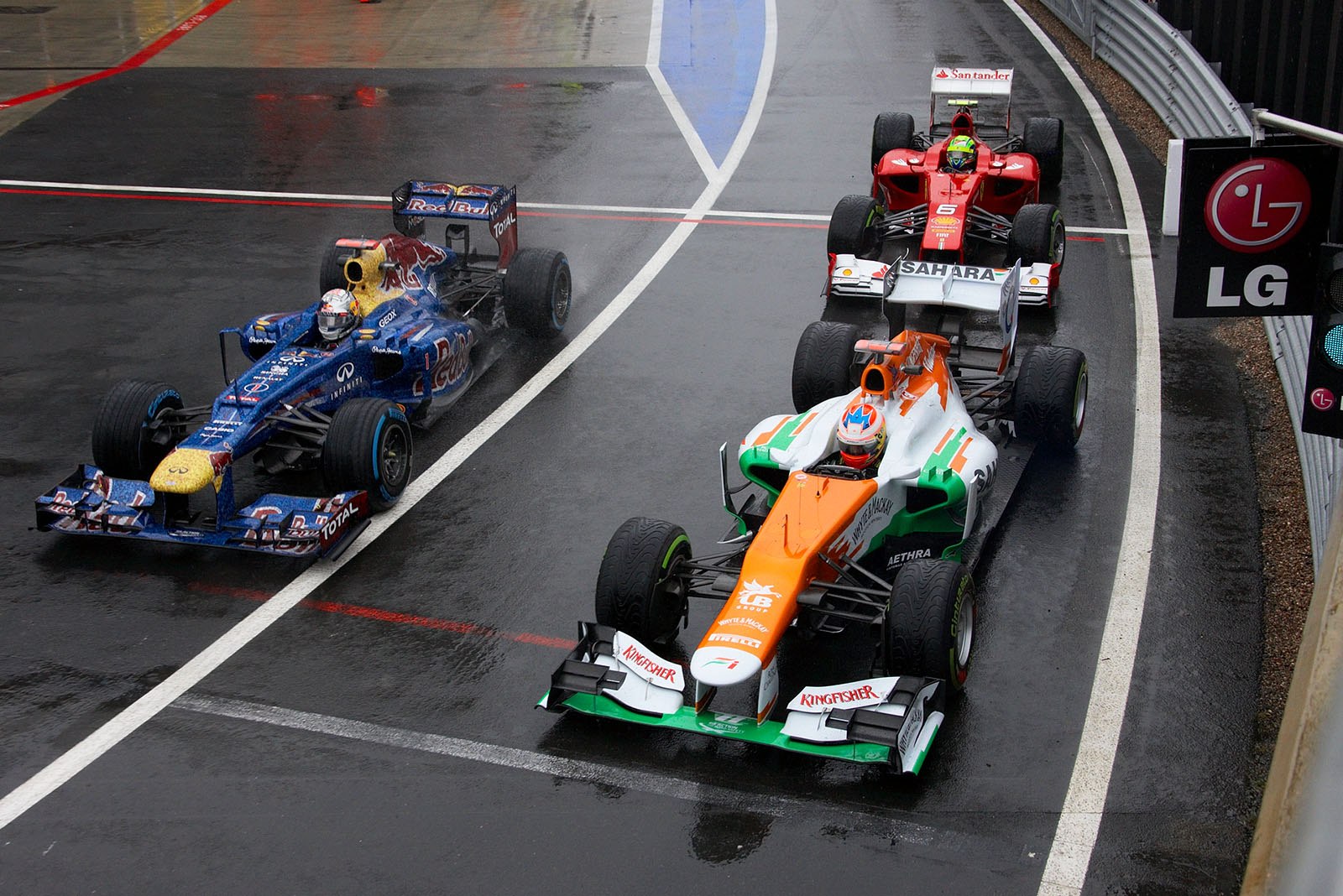 Paul di Resta of Force India, Sebastian Vettel of Red Bull Racing and Felipe Massa of Ferrari practise launches in the rain at pit lane exit