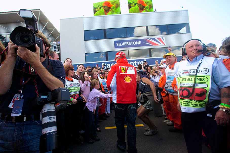 Kimi Raikkonen gives a quick autograph