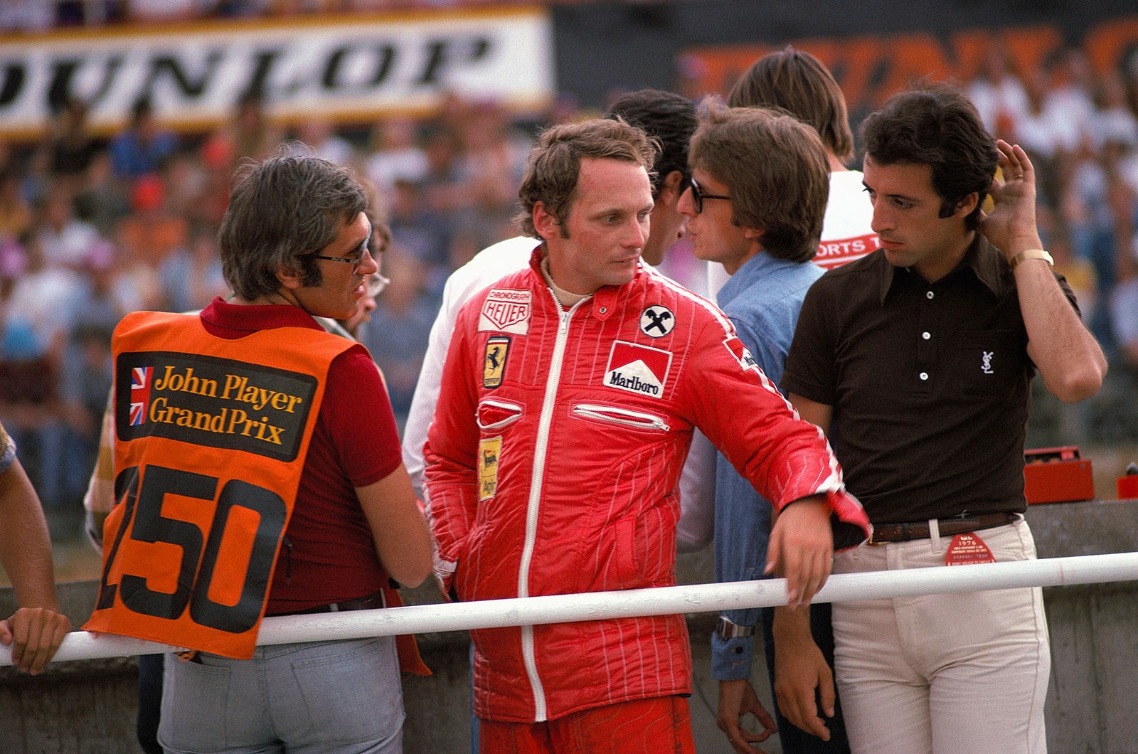 Ferrari driver Niki Lauda. Next to him on the left side is Austrian journalist Helmut Zwickl. On the right Luca di Montezemolo and Piero Lardi Ferrari (brown T-shirt).