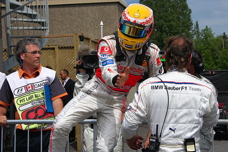 Winner Lewis Hamilton jumps over the fence of parc ferme and a swiss mechanic, on the way to caress his team in overwhelming emotions