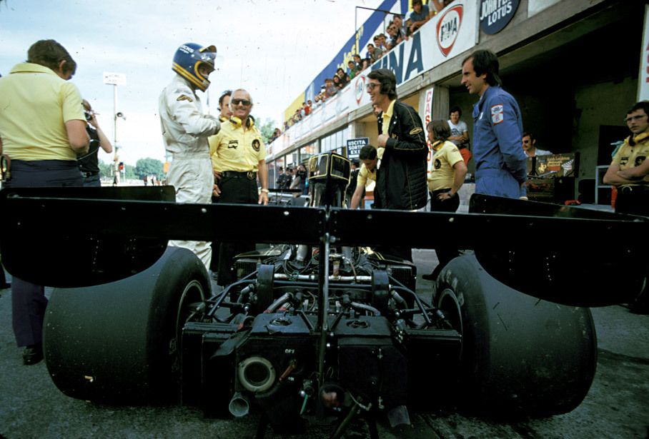 Ronnie Peterson in the pits, teamboss Colin Chapman and teammanager Peter Warr alongside him