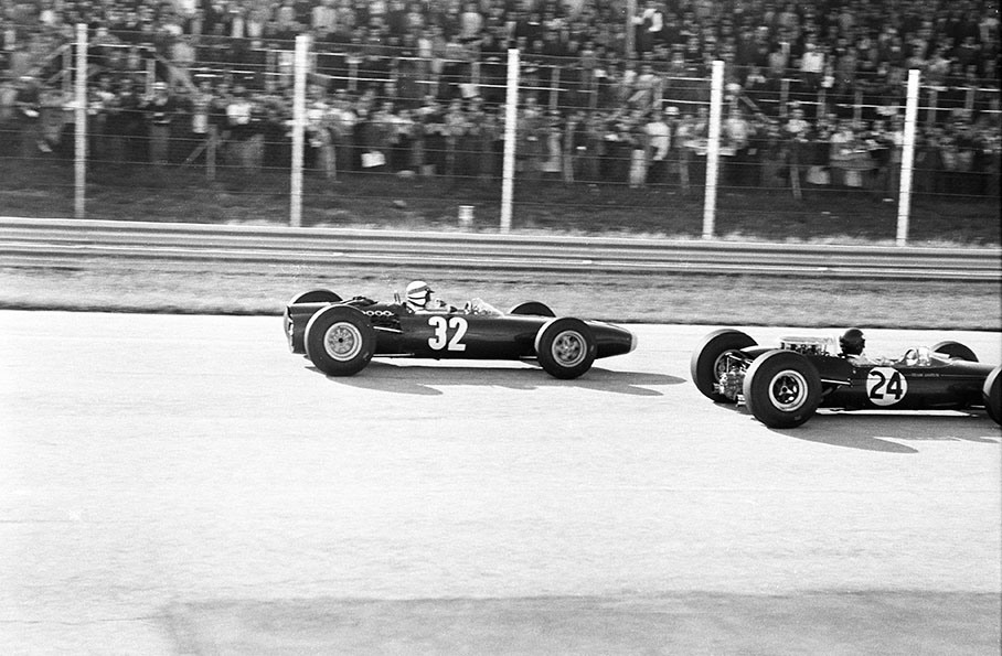 Race winner Jackie Stewart on a BRM P261 and Jim Clark in a Lotus-Climax 33 (car no. 24, started from pole position but retires with fuel pump problems after 63 of 76 laps) fight wheel to wheel for the lead during the Italian GP at Monza in 1965.