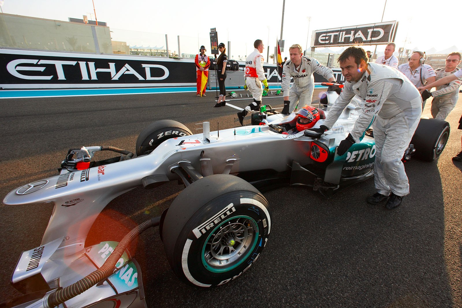 Michael Schumacher is pushed to his grid position by the Mercedes GP mechanics