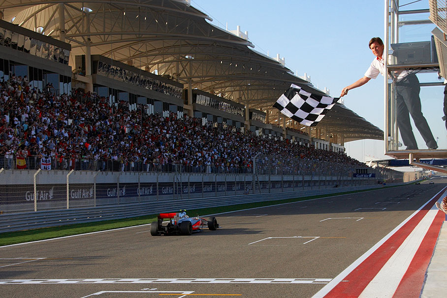 Third placed Hamilton takes the chequered flag from Bahrain International Circuit's CEO Martin Whitaker