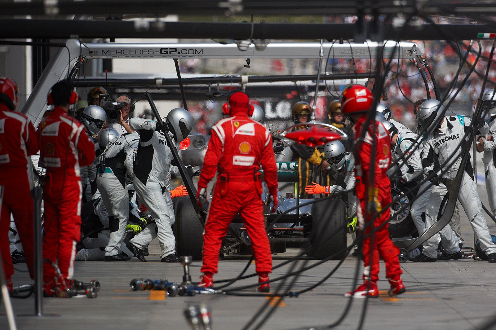 Ferrari mechanics watch Michael Schumacher's third pit stop in lap 30