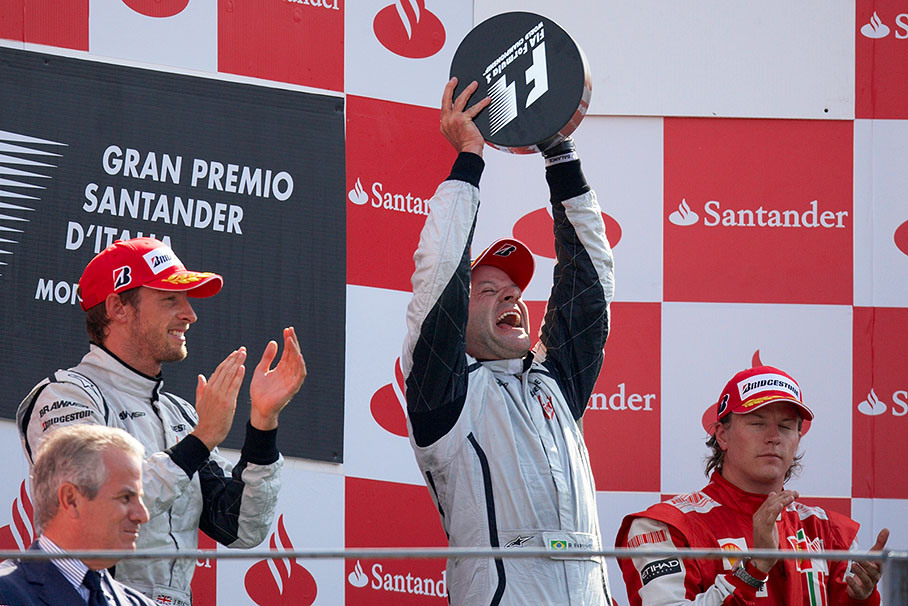 Second placed Jenson Button and third placed Kimi Raikkonen of Ferrari clap their hands for the happy winner Rubens Barrichello