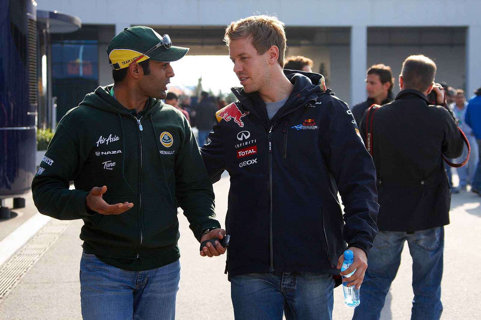 Karun Chandhok and Sebastian Vettel walk back together from drivers' briefing