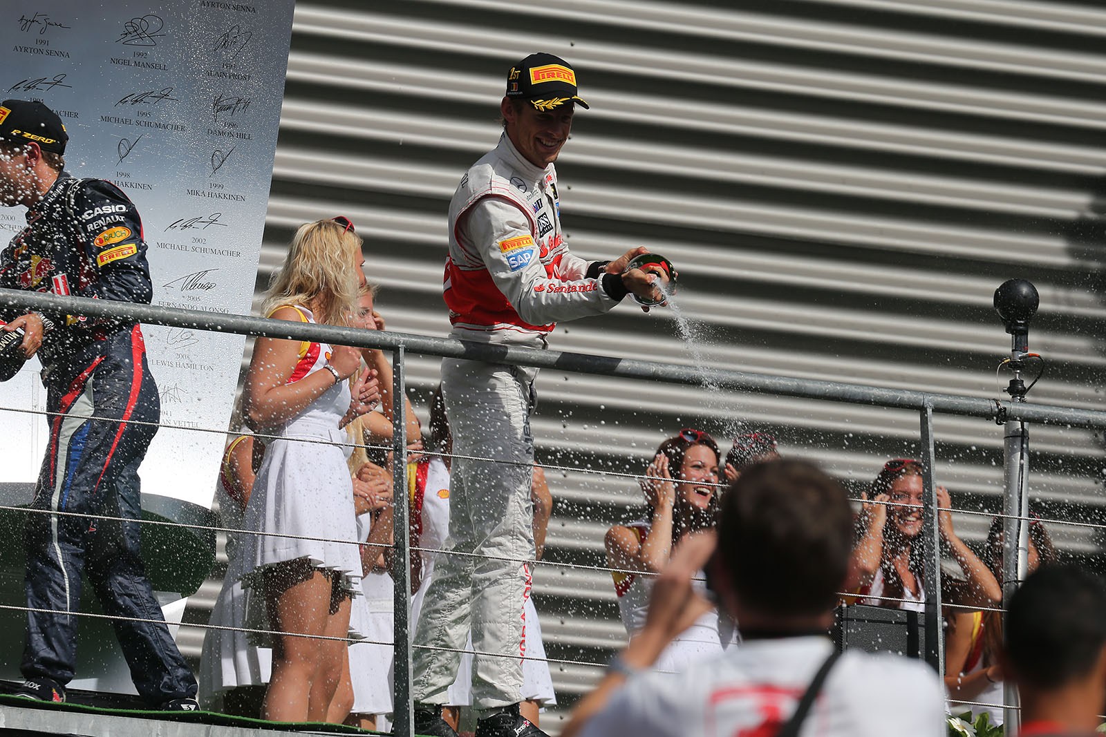 Race winner Jenson Button of McLaren sprays champagne after the podium ceremony