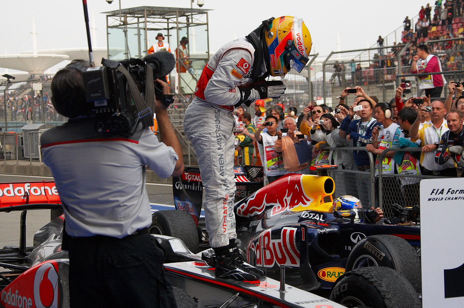McLaren's race winner Lewis Hamilton jumps on the car in parc ferme after the Chinese GP besides second placed Vettel