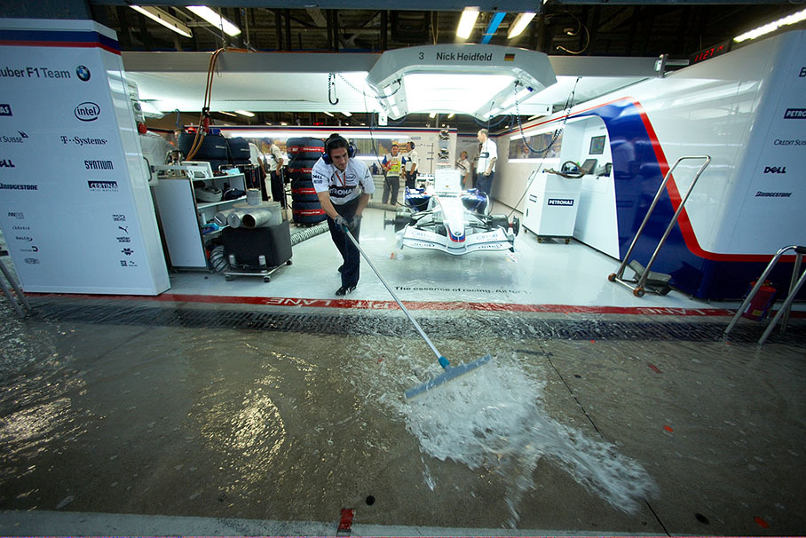 Water from a heavy downpour floods the garages during Friday morning practice.