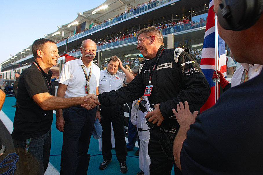 Dr. Dieter Zetsche, Chairman of the Board of Management of Daimler AG, Mercedes Motorsport Director Norbert Haug and another gentleman (identification appreciated) shake hands on the grid with World Champion Ross Brawn