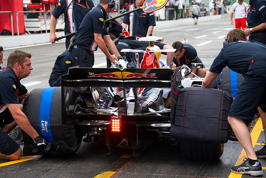 David Coulthard practices a pitstop with the Red Bull pit crew